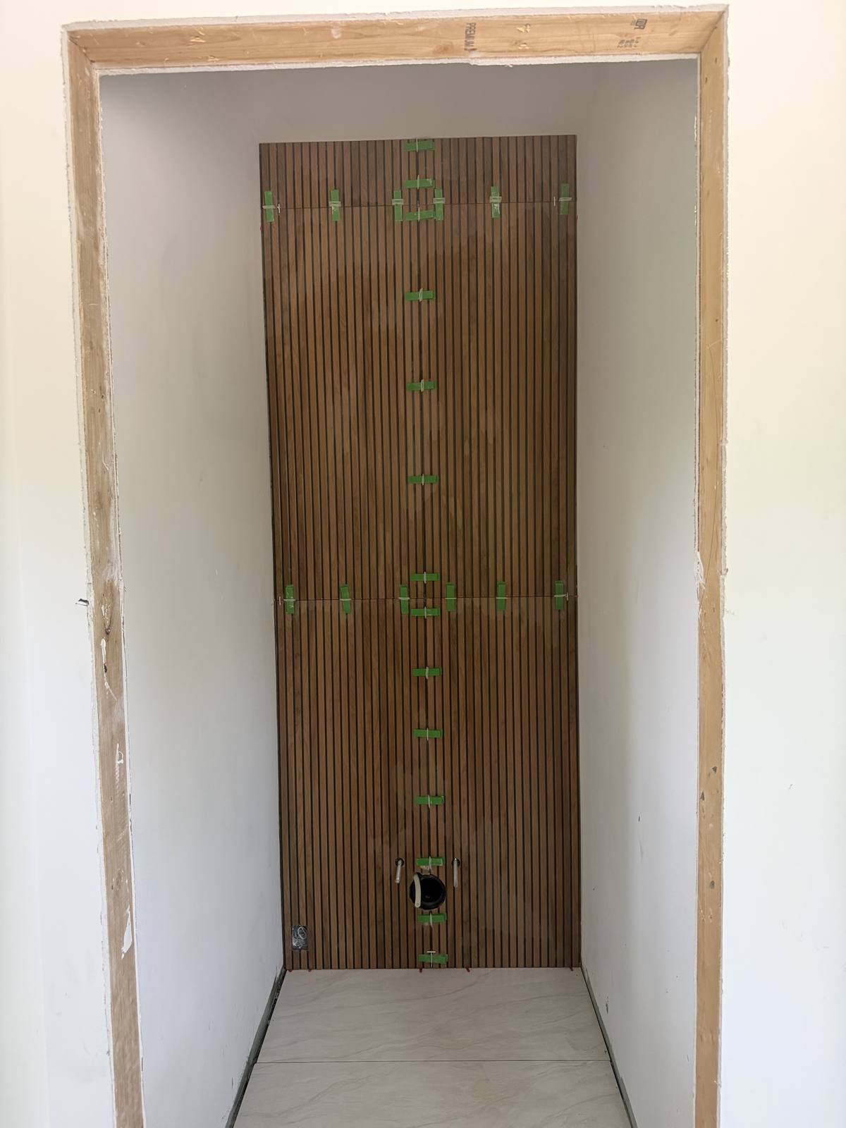 Powder room wood slat feature wall — during install